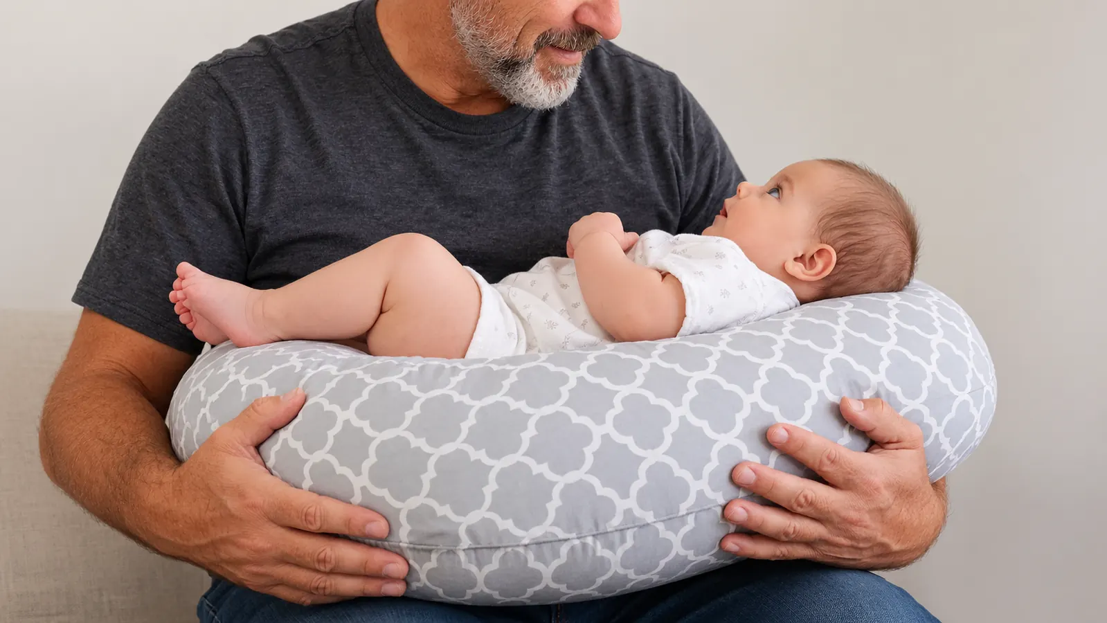 Close view of a nursing pillow around a parent's waist, with a baby resting on the flat surface